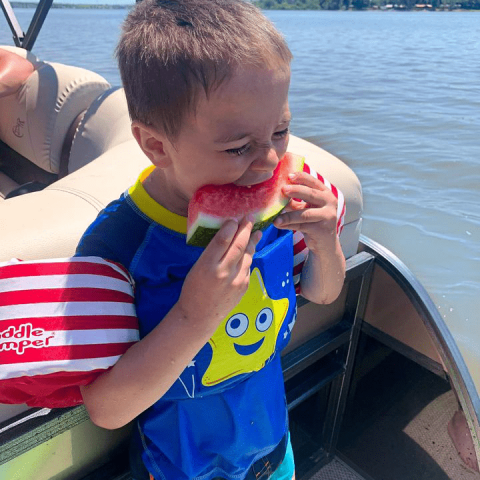 a boy drinking water from a boat
