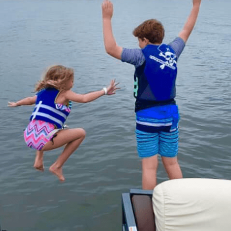 a group of people standing next to a body of water