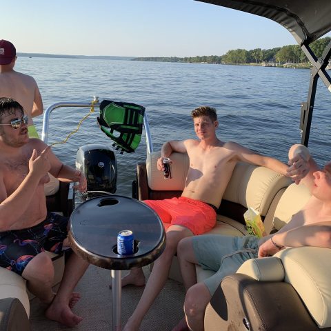 a group of people sitting in a boat on a body of water