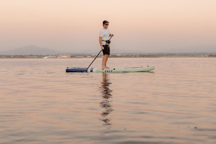a man standing next to a body of water